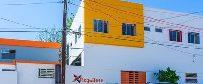 Fachada de Reguilete Jardín de Niños en Tijuana, con el logotipo del rehilete junto al portón de entrada
