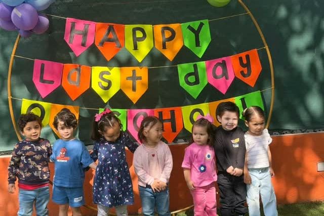 Grupo de alumnos de Reguilete frente a un arco de globos de colores el último día de clases